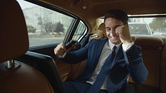 男人在现代汽车里玩手机很开心视频的预览图