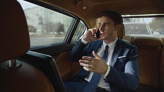 专注于汽车的商人通过电话交谈视频的预览图