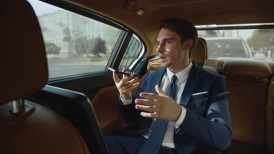 关键商人使用汽车的手机记录语音信息视频的预览图