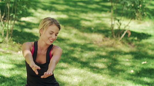 微笑的女人在公园健身前伸腿视频的预览图