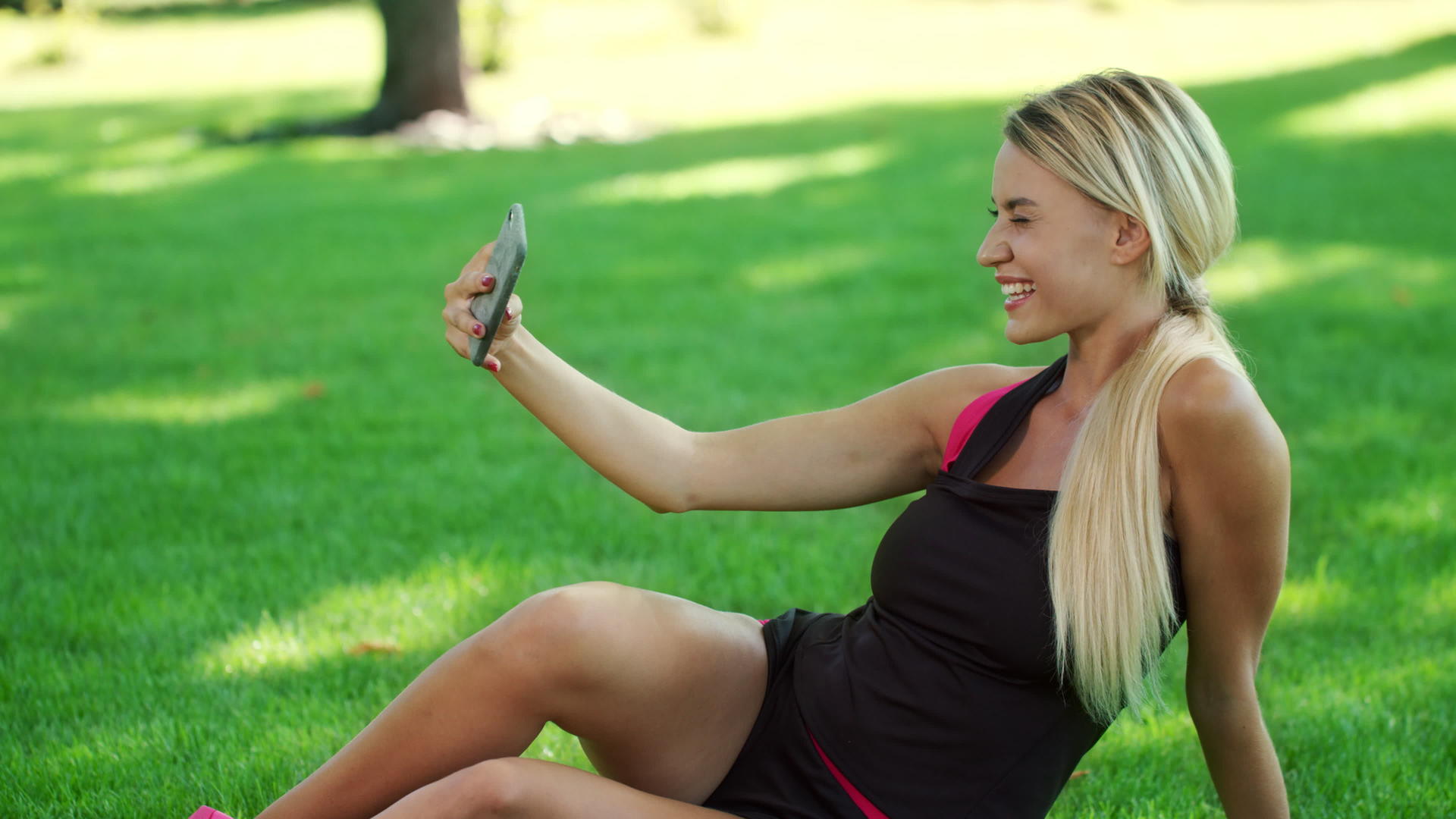 微笑的女人用公园手机拍照视频的预览图