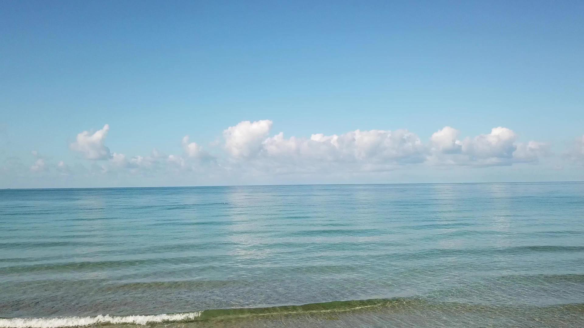 白云和清澈的海水闪闪发光视频的预览图