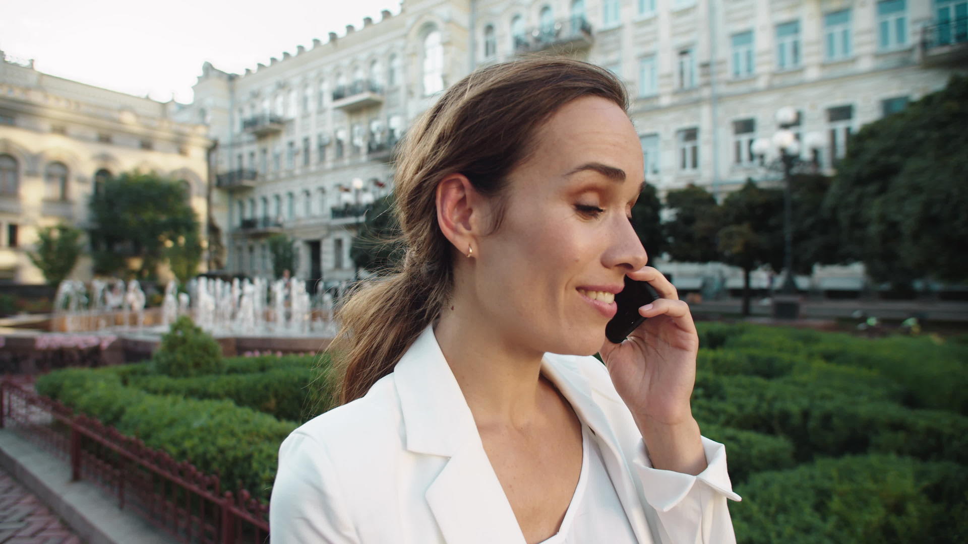 快乐的商业女性在城市散步时用手机聊天视频的预览图