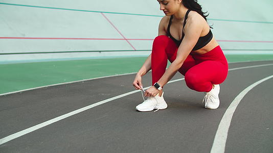 运动女性在赛道上穿鞋和健身视频的预览图