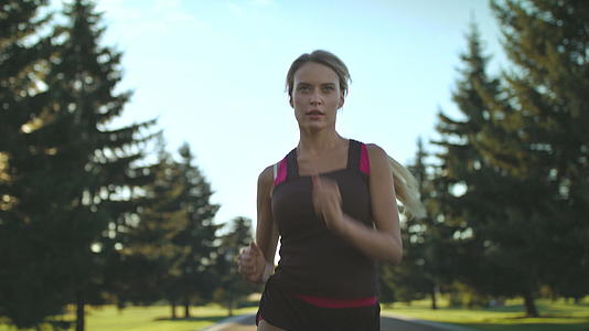 夏天在公园路上跑步的女运动员视频的预览图