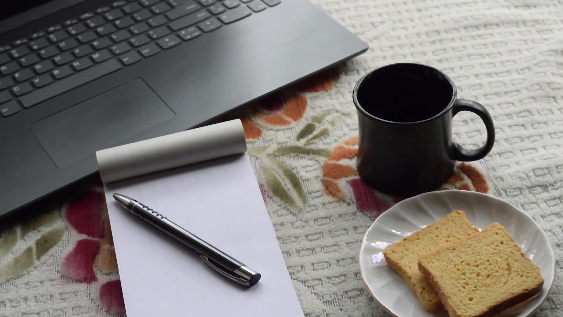 早餐咖啡和笔记本电脑黑笔和白纸笔记本电脑视频的预览图