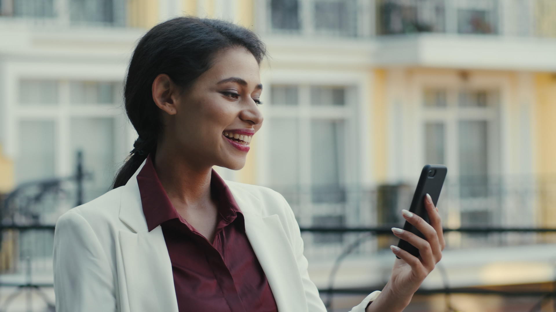 混合种族女商人在户外有视频聊天微笑的女人会说话视频的预览图