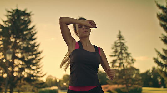 女运动员在公园里面边跑步边擦汗视频的预览图