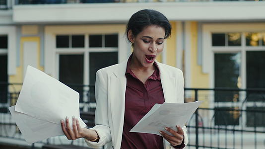 女商人在城市街头阅读文件成功签约合作开心快乐视频的预览图