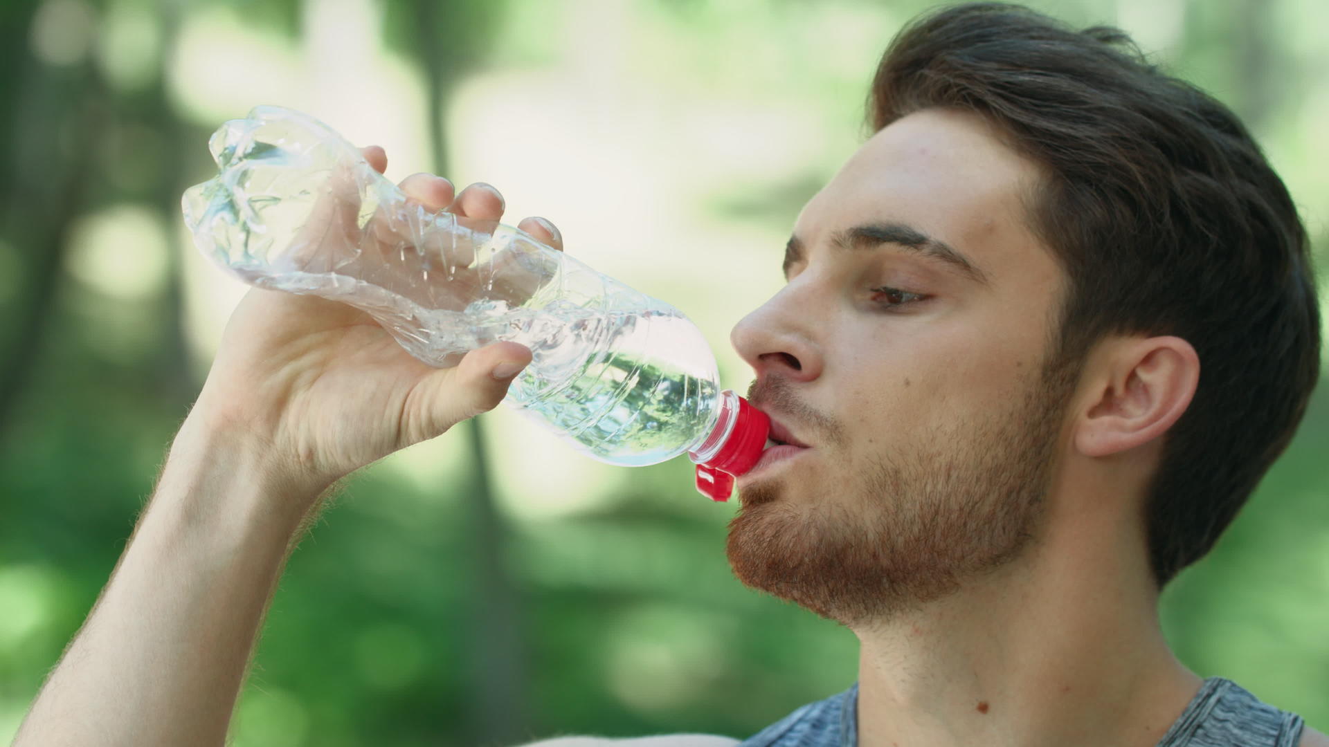 夏天在公园酒瓶里喝水的人口渴视频的预览图