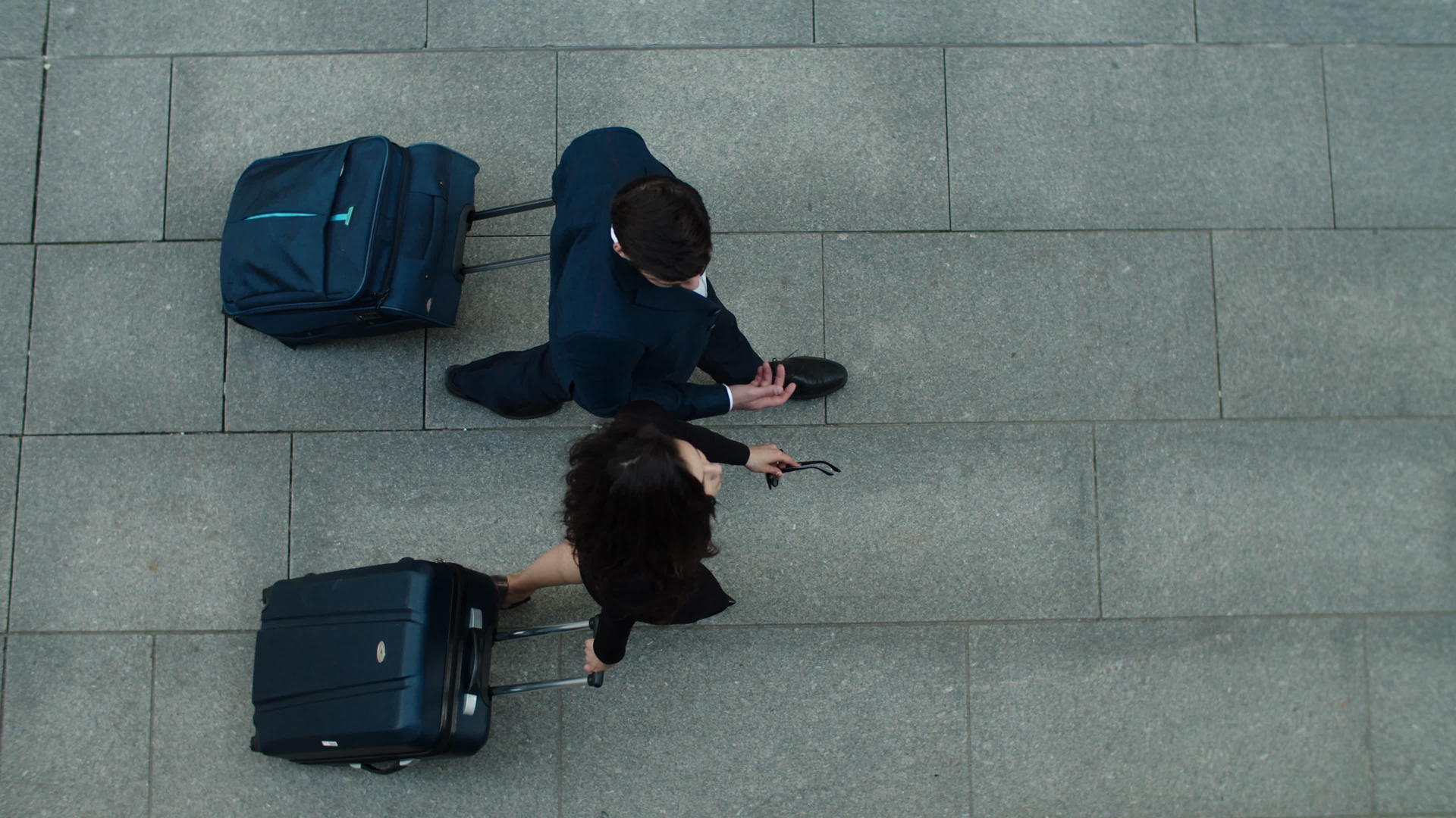 商务人士和商业伙伴在户外旅行时俯拍拉着行李箱视频的预览图