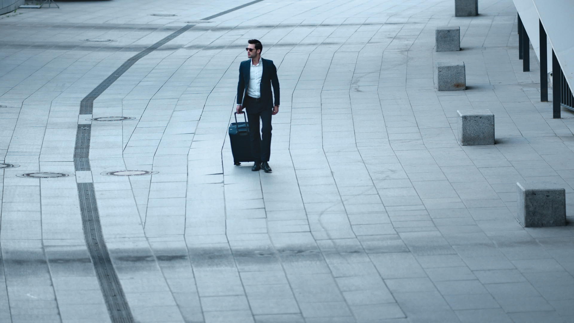 拿着行李箱走在街上帅气的白领商务男人戴着墨镜视频的预览图
