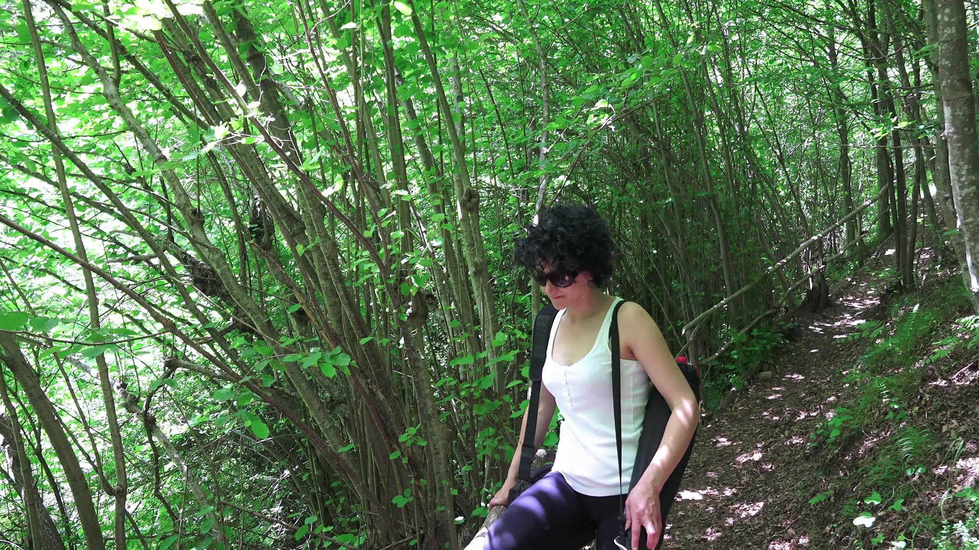 年轻的西班牙女孩在绿林中行走享受大自然的美丽视频的预览图