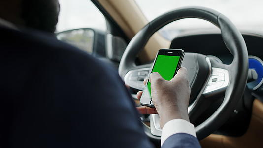 男性驾驶员使用绿色屏幕手机触摸屏打字视频的预览图
