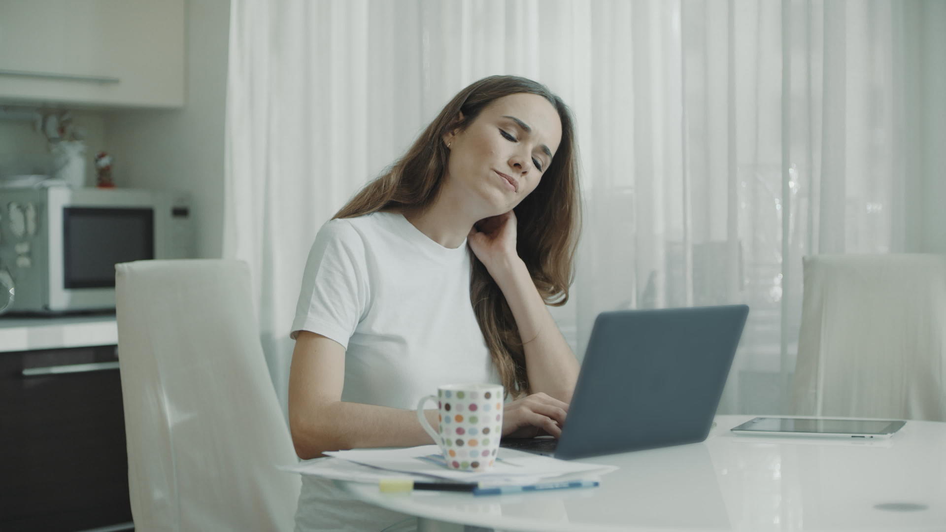 在家从事膝上计算机工作的疲惫女性视频的预览图