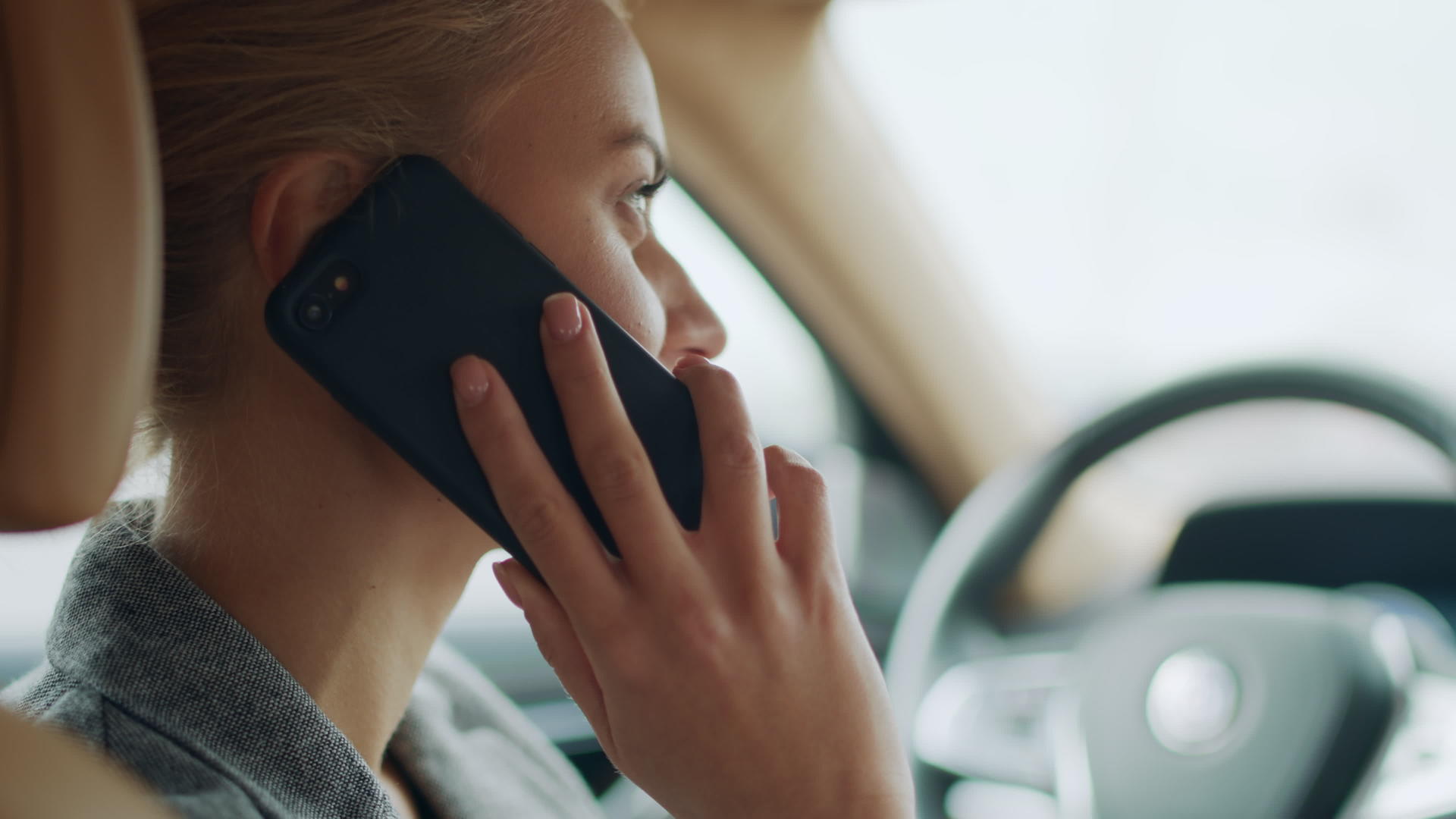 女性在驾驶座上用手机打电话的侧面特写视频的预览图