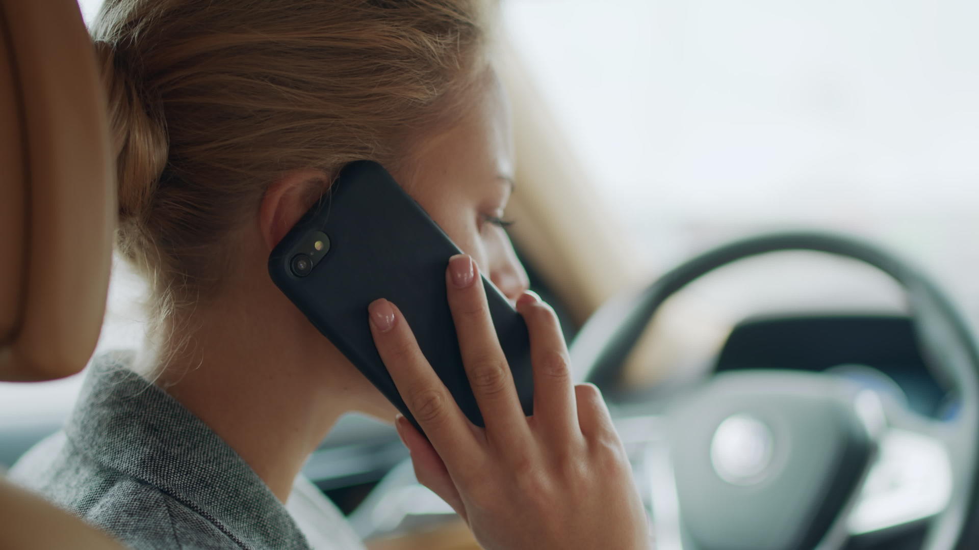 女性在驾驶座上用手机打电话的侧面特写视频的预览图