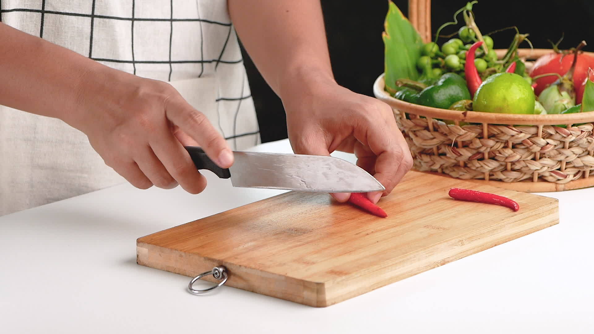 女人用切割板上的刀把红辣椒切成块视频的预览图