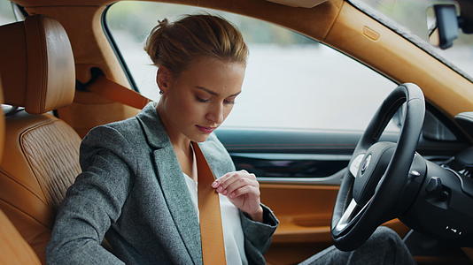商务白领女性在驾驶座上系安全带视频的预览图