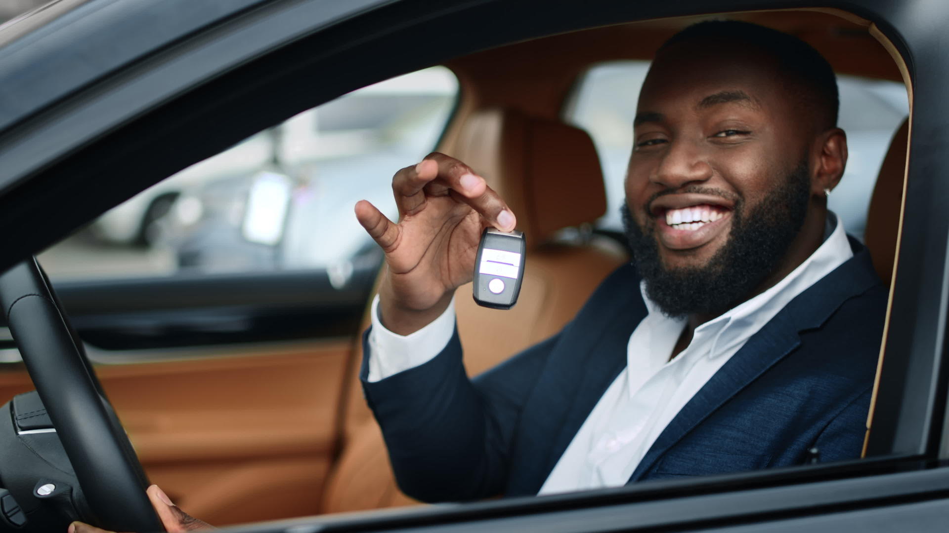 男人坐在驾驶座上拿到新车钥匙对着镜头微笑视频的预览图
