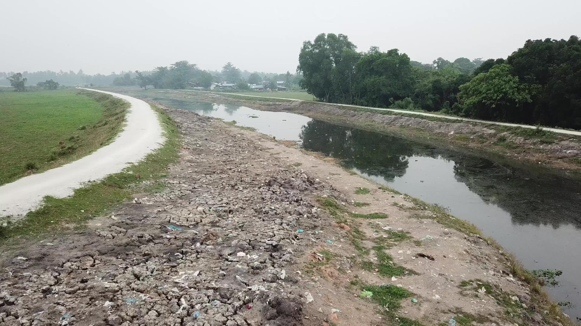垃圾堆散落在污染河流附近的裂缝中视频的预览图