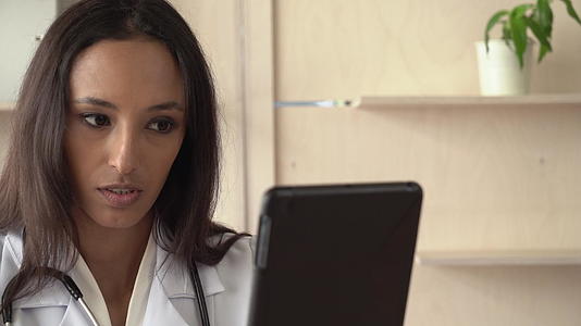 专业女性通过互联网作为医生聊天视频的预览图