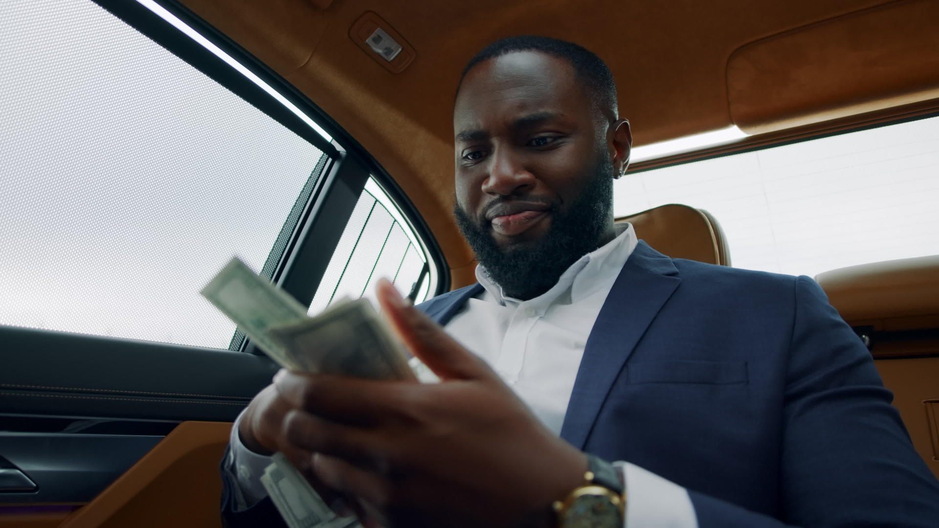 白领男人在车后座快乐地数现金视频的预览图