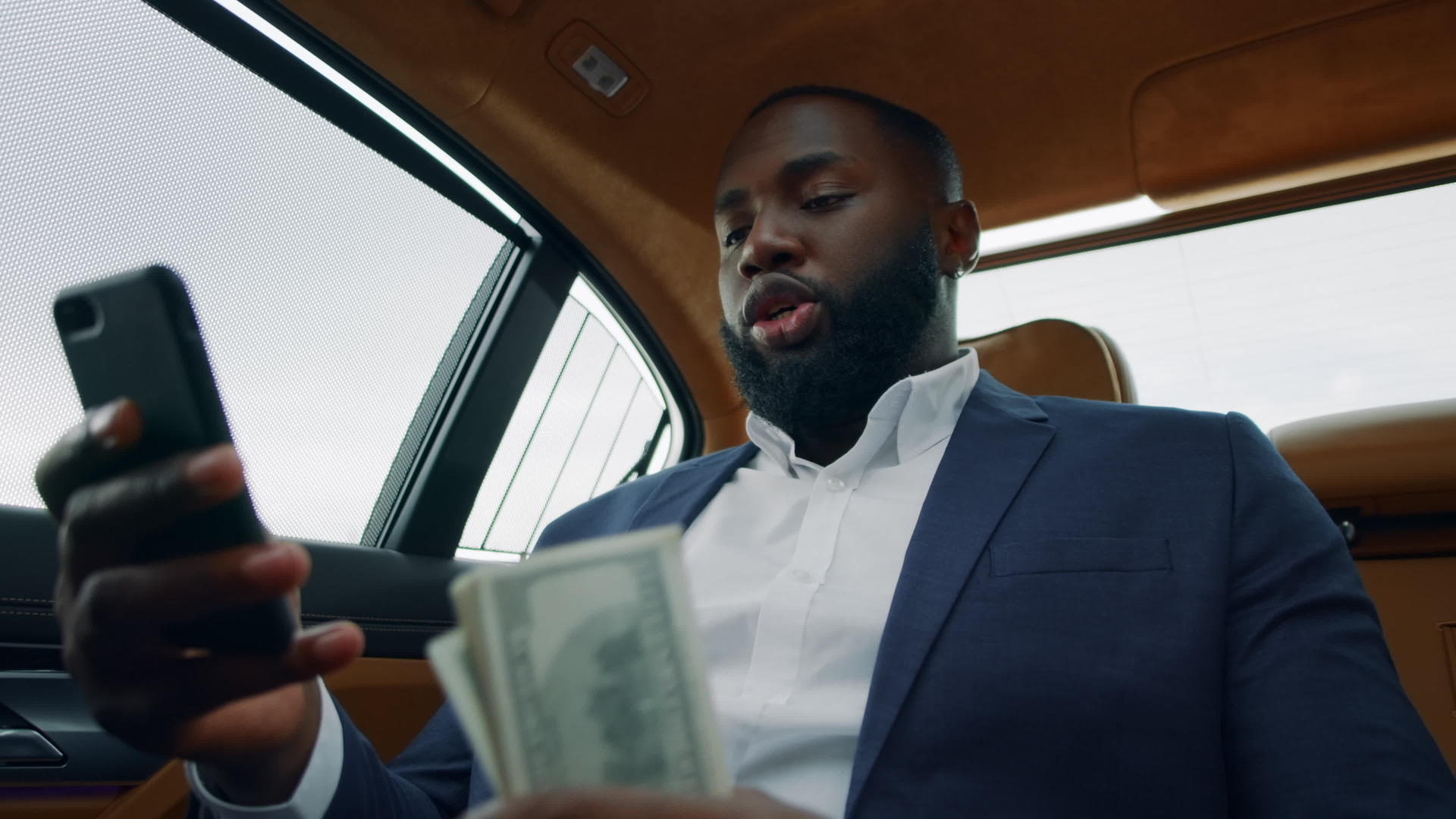 白领男性在汽车后座用现金视频通话视频的预览图