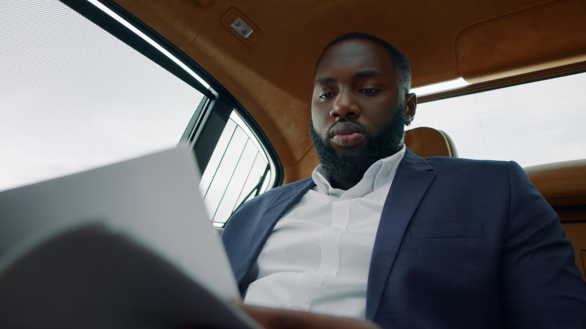 白领男性在汽车后座认真阅读文件视频的预览图