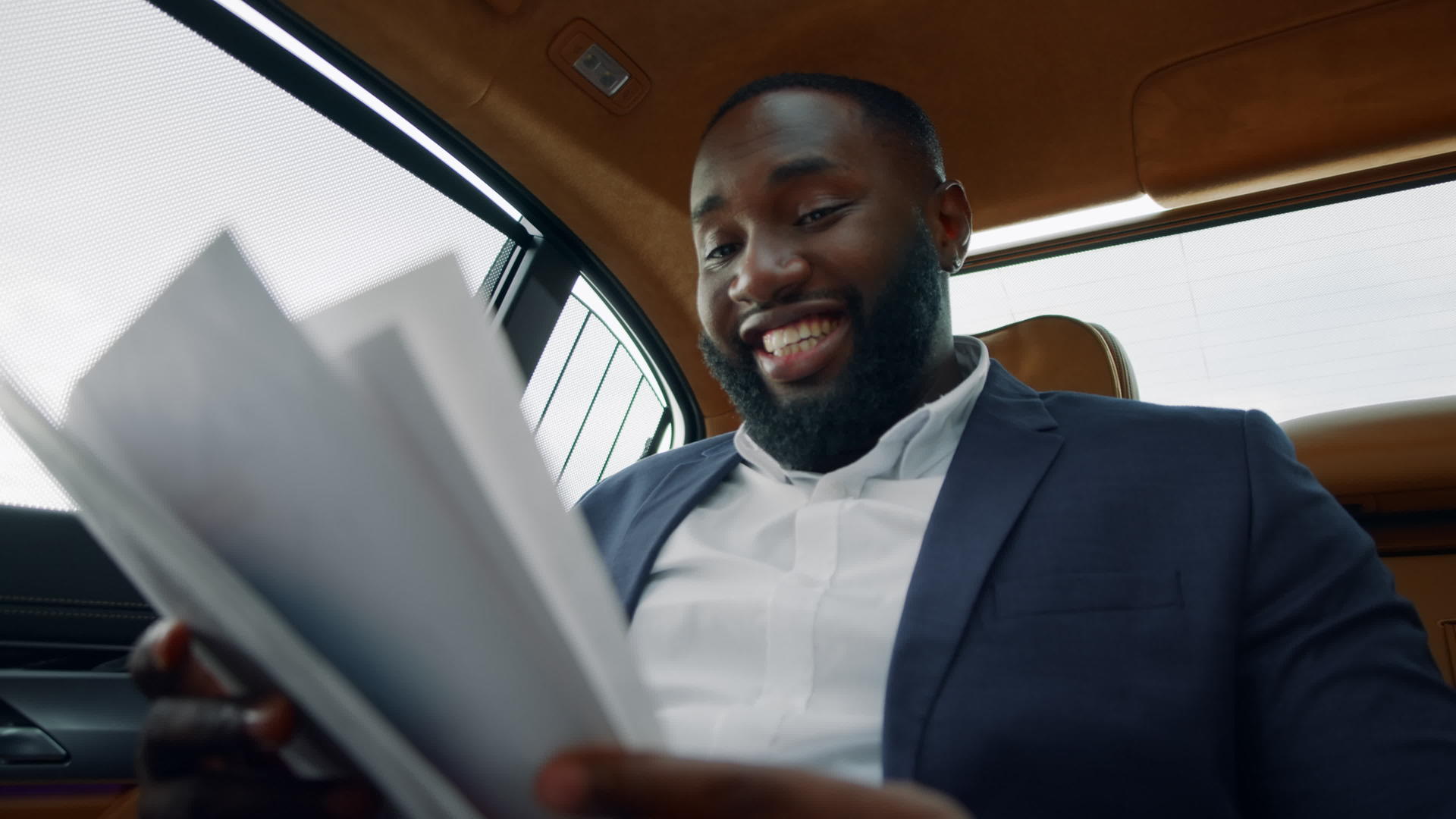 看着汽车后座上的签约文件白领男微笑视频的预览图