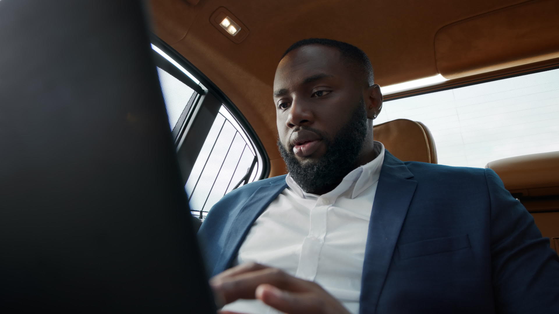 坐在车后座的白领男人用笔记本电脑愉快地聊天和交流视频的预览图
