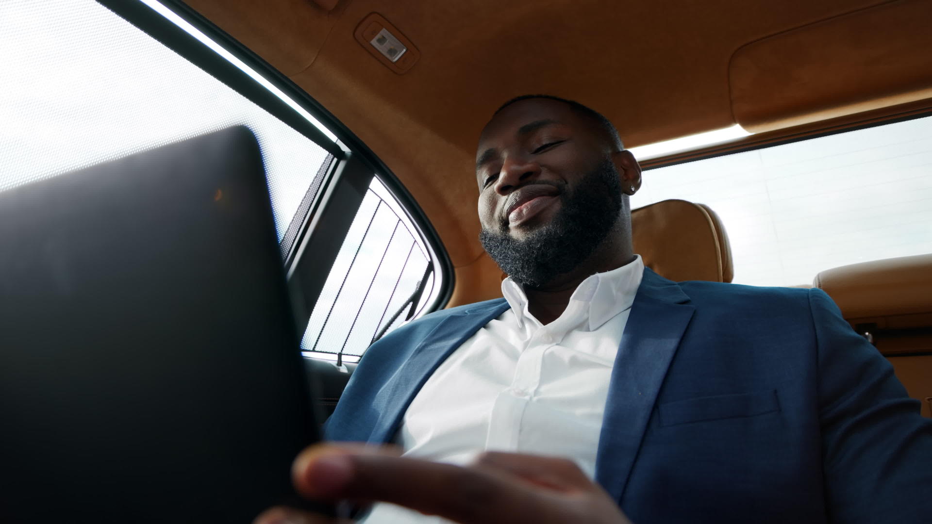 汽车后座白领男性使用笔记本电脑工作谈话视频的预览图