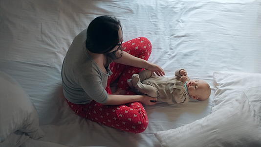 躺在床上的女人穿着睡衣可爱的孩子视频的预览图
