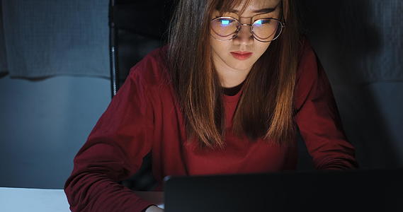 亚洲女性在深夜用笔记本电脑工作家庭办公室视频的预览图