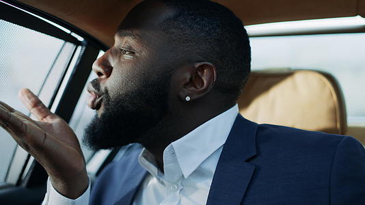 非洲商务男肖像在汽车后座吹吻视频的预览图