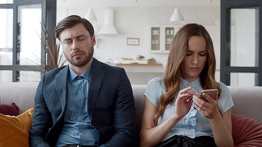 年轻夫妇坐在现代房间的沙发上视频的预览图