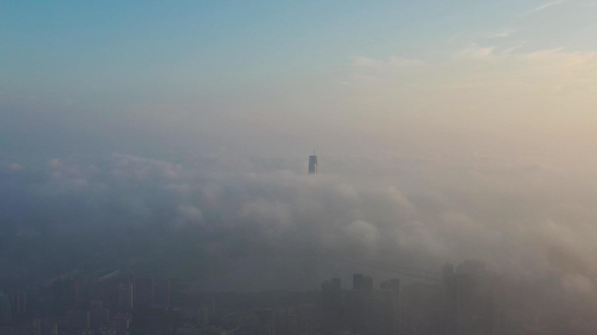 航拍穿过平流雾的城市高楼和雾中城市视频的预览图