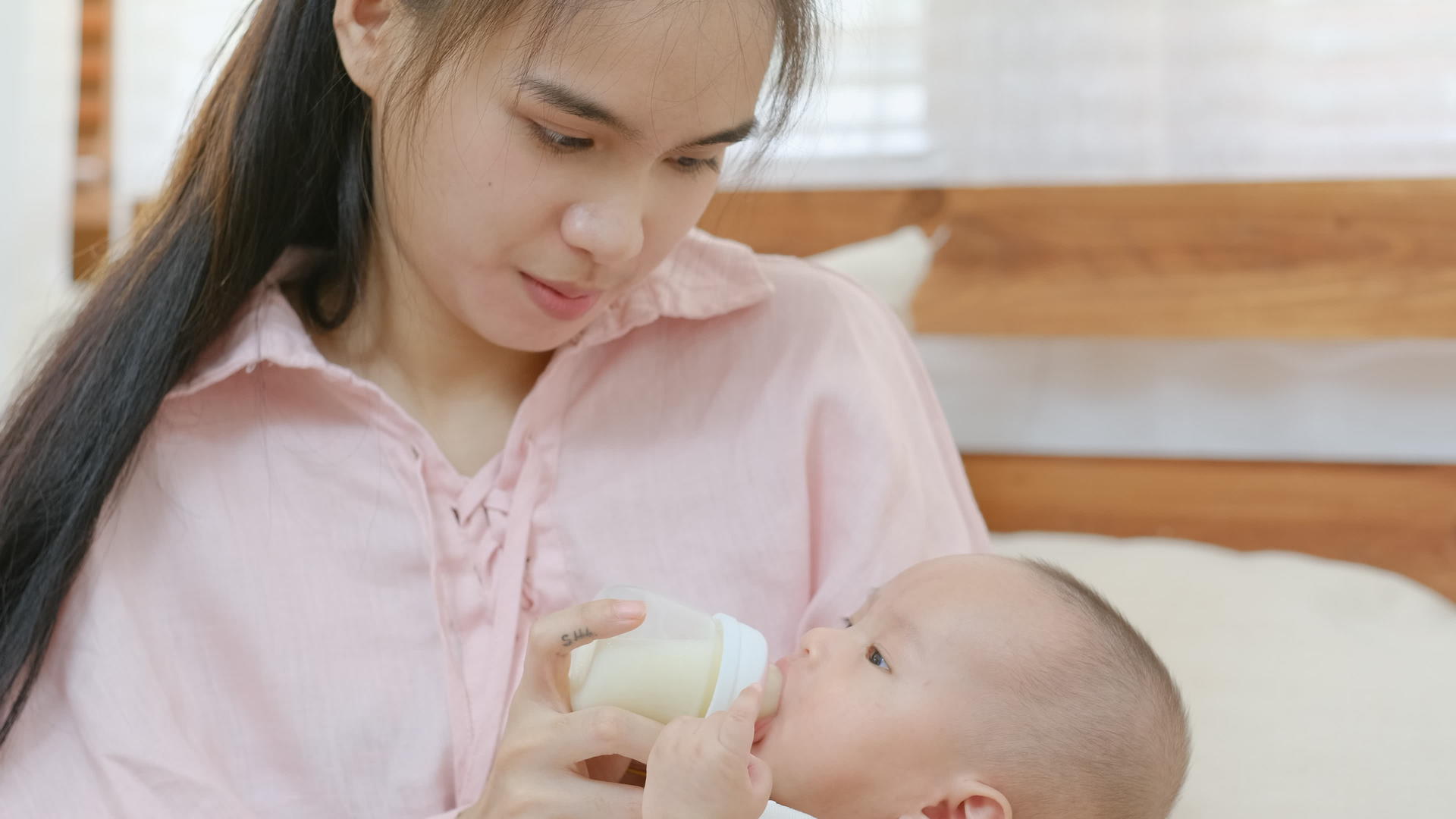 年幼的母亲用奶瓶喂新生儿视频的预览图
