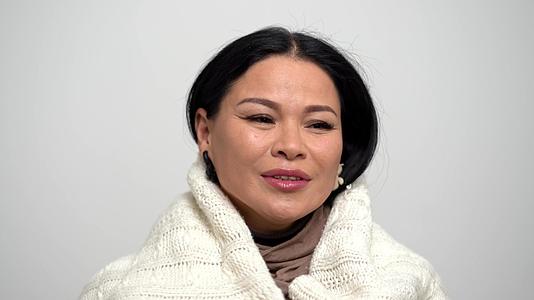 温暖的亚洲女性裹着白色围巾视频的预览图