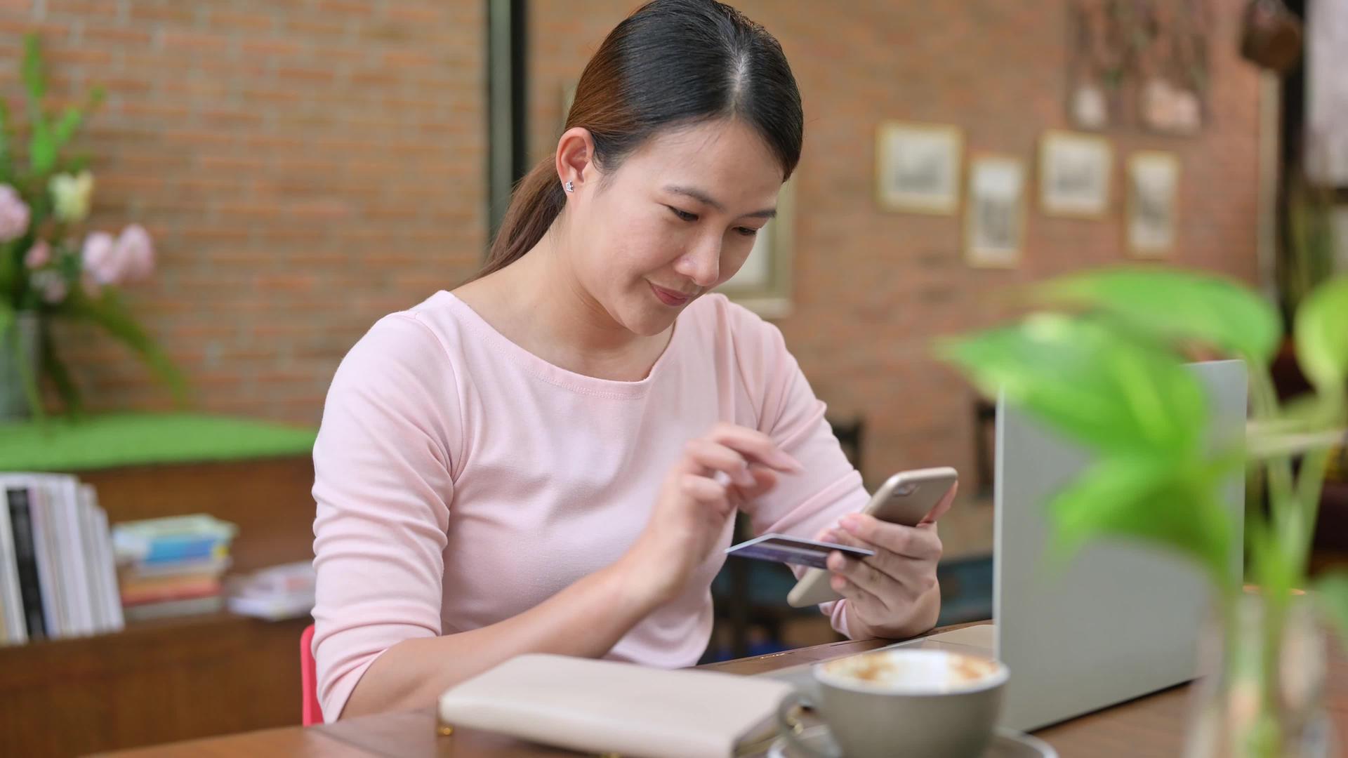 亚洲女性使用信用卡在网上购物和送货上门视频的预览图