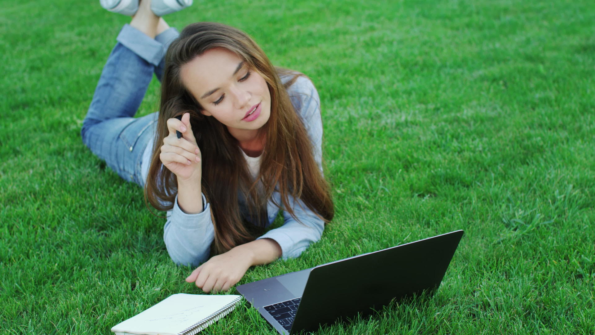 年轻女性在公园里使用膝盖计算机自由工作视频的预览图