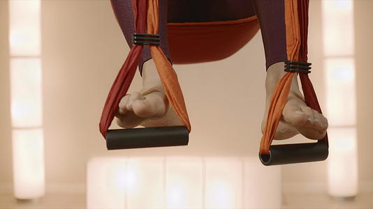 体操运动员在瑜伽工作室的吊床上伸展视频的预览图