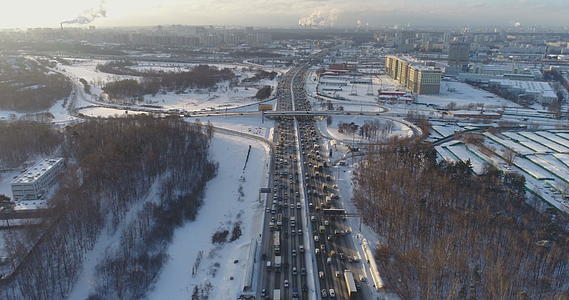 在一个阳光明媚的冬天寒冷的早晨城市高速公路上的汽车交通城市景观向前飞视频的预览图