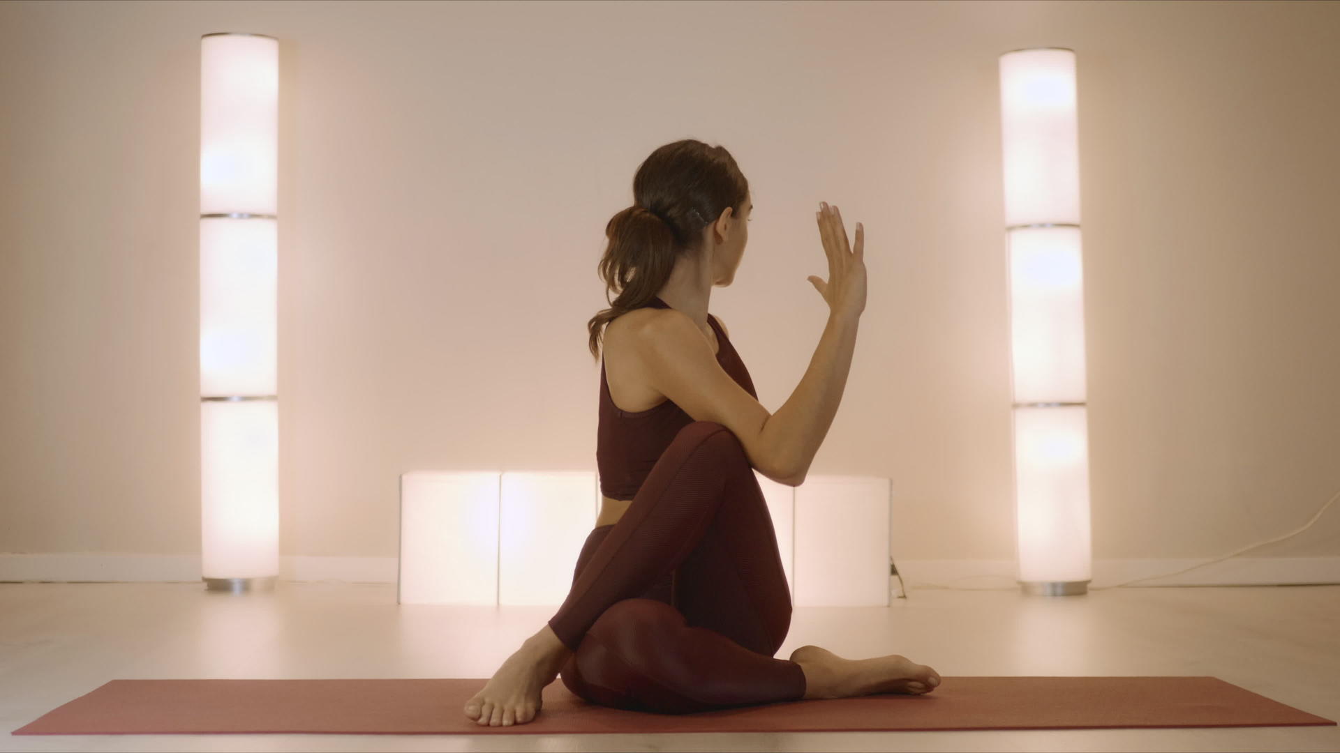 坐在瑜伽垫上做脊椎曲折姿势的女性视频的预览图