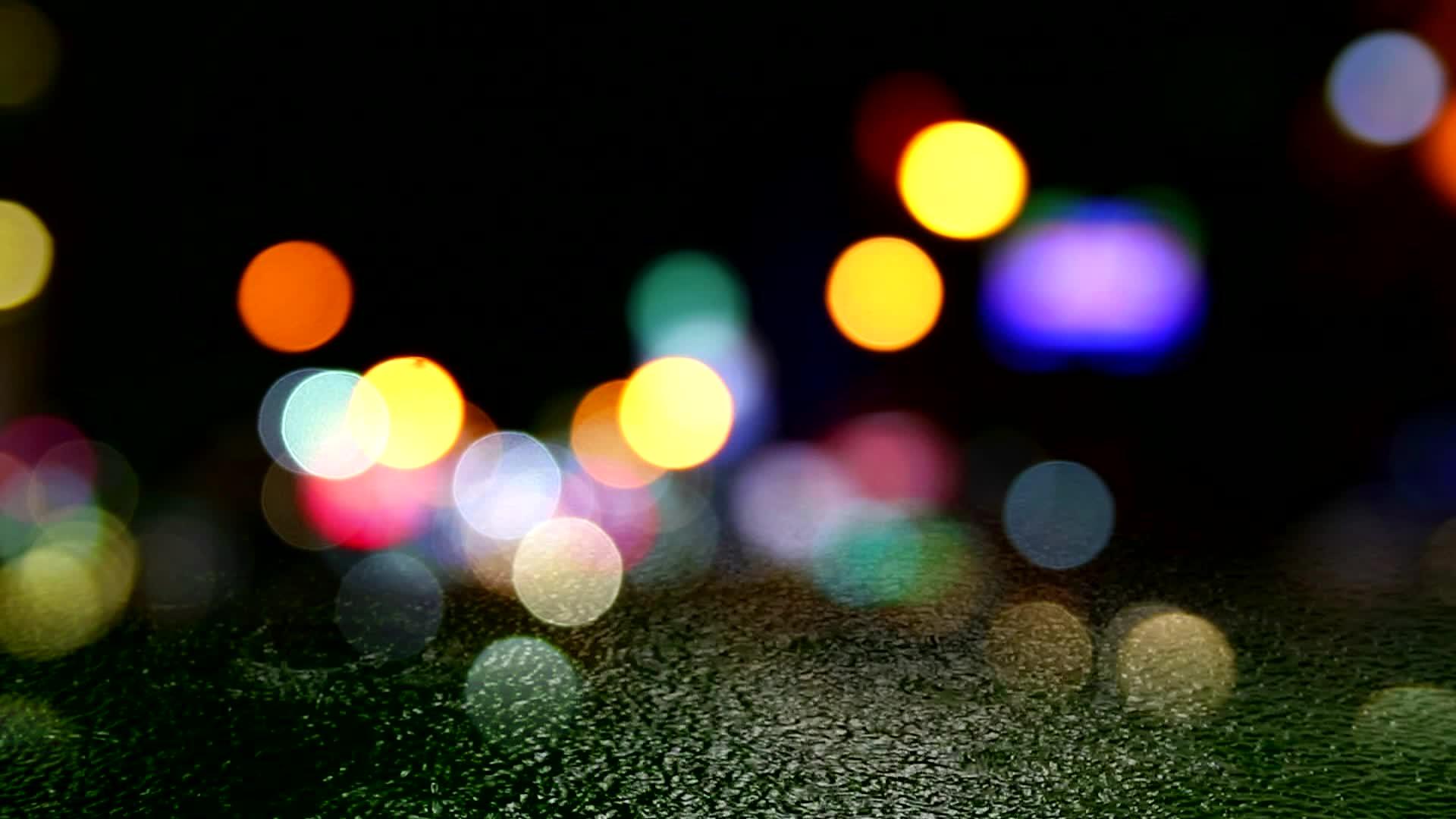 晚上许多车厢在模糊的交通窗口前有模糊的雨滴视频的预览图
