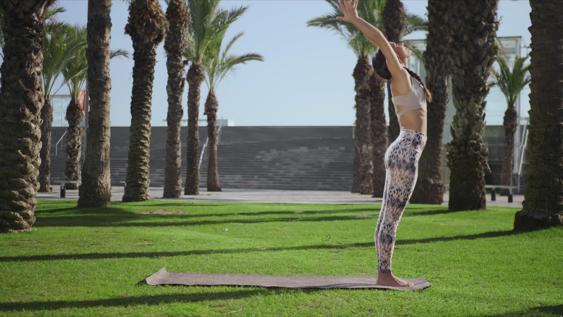 女人在公园的棕榈树下做瑜伽视频的预览图
