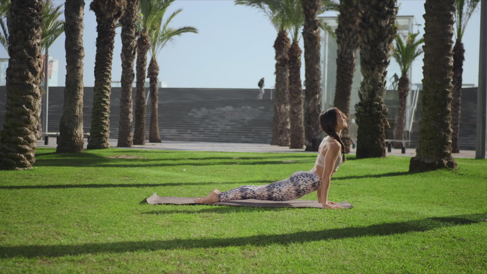瑜伽教练在公园里做眼镜蛇姿势视频的预览图
