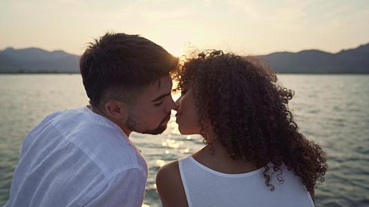 一对多种族夫妇在背光下亲吻的特写镜头视频的预览图