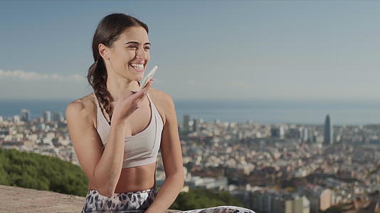 在巴塞罗那的背景下瑜伽教练使用手机语音视频的预览图