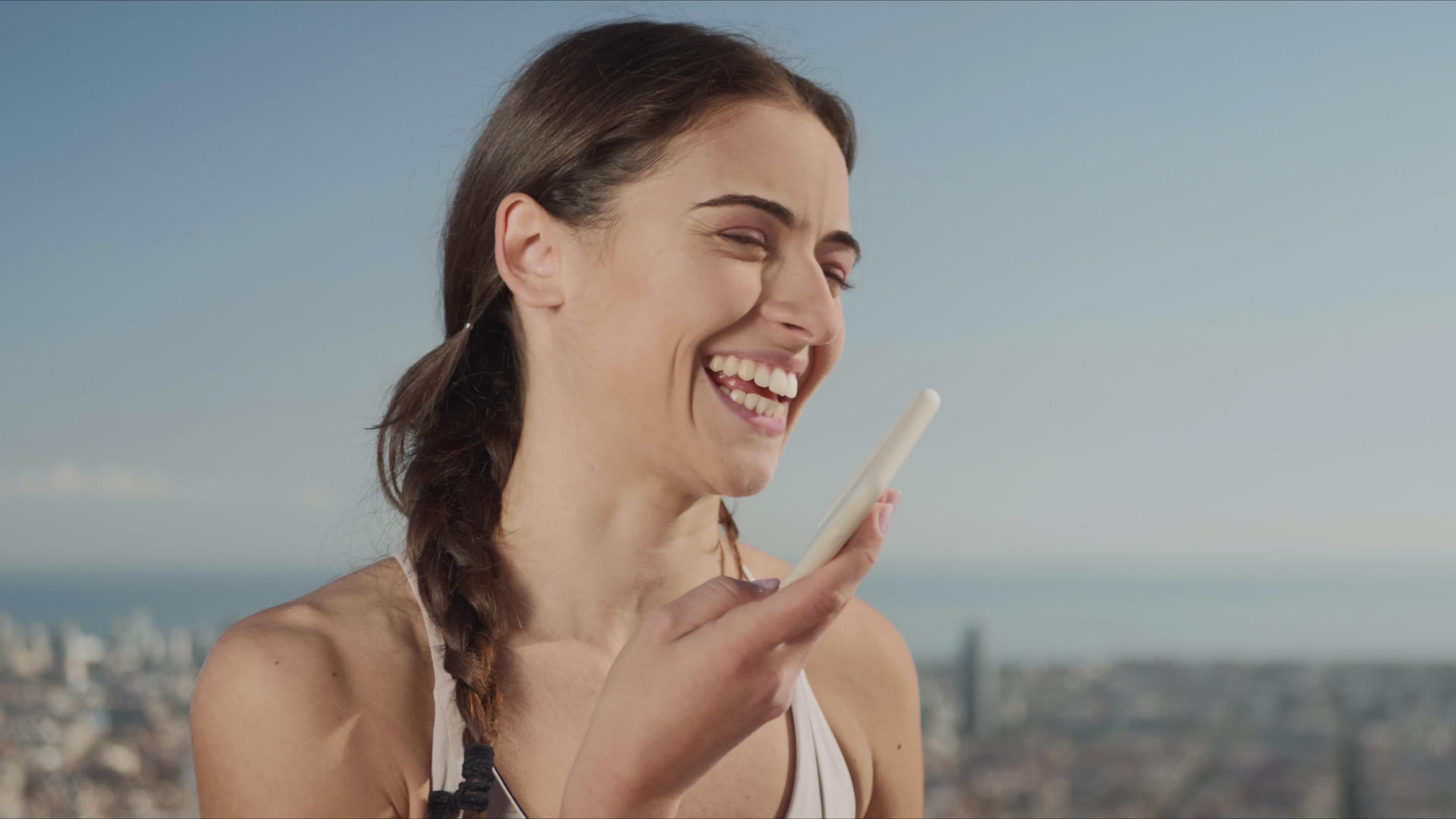 微笑的女士在街上用手机录音留言视频的预览图
